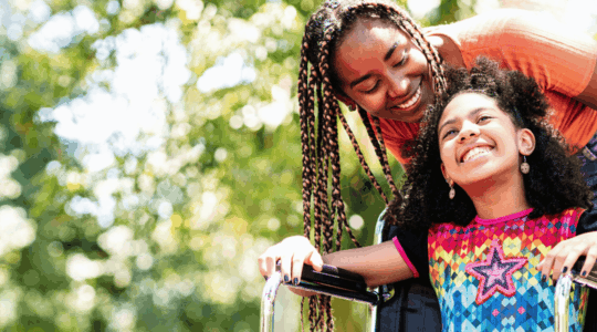 Child-in-wheelchair-at-park-with-mom